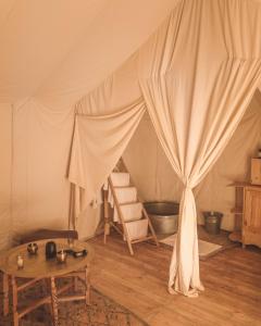 a room with a tent with a table in it at Arabian Horse camp in Badīyah