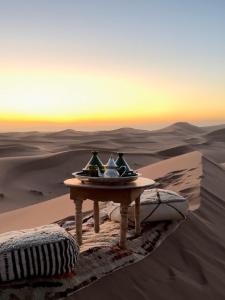 a table in the desert with two tea pots on it at Arabian Horse camp in Badīyah