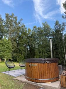 a large wooden tub with two chairs in a park at Alexandra Forest Lake House in Konsu