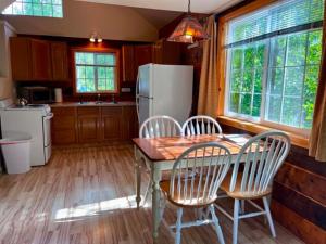 a kitchen with a table and chairs and a refrigerator at Denali Fireside Cabin & Suites in Talkeetna