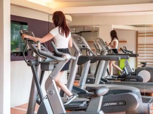 two women on treadmills on a gym treadmill at Hotel Novotel Evry Courcouronnes in Courcouronnes