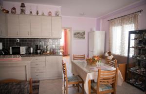 a kitchen with a table and chairs and a refrigerator at Irida Suite in Salamina