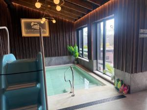ein Pool in einem Raum mit einem Stuhl und einem Schwimmbecken in der Unterkunft Ferdinands SPA in Alūksne