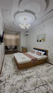 a bedroom with a large bed and a ceiling at Anor Avenue Hotel in Tashkent