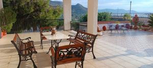 a patio with chairs and a table with a cat on it at Irida Suite in Salamina