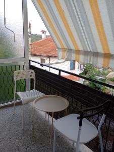 a balcony with two chairs and a table and a window at E2 Residence in Balchik +16 photos