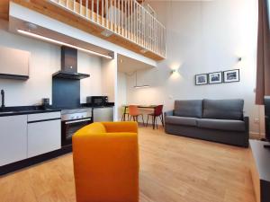 a kitchen and living room with a couch and a table at Apartamentos Mantería Lacort, Valladolid in Valladolid