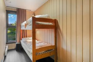 two bunk beds in a room with a window at Cozy Mountain Beito - 18 sengeplasser - bilijard in Beitostøl