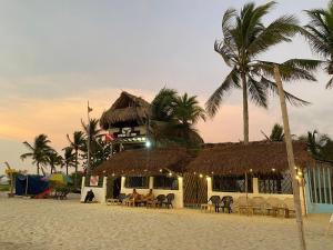 a restaurant on the beach with a straw roof at El Rincón de Juan in San Onofre