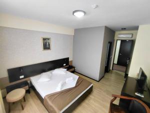 a hotel room with a bed and a chair at Hotel Nord in Ploieşti