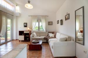 a living room with a white couch and a table at THEA MARE villa in Nea Potidaea +78 photos