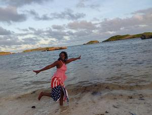 a woman running on the beach in the water at Diamond luxury Studio Watamu in Watamu