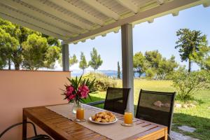 a wooden table with a plate of food on a patio at THEA MARE villa in Nea Potidaea