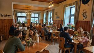 a group of people sitting at tables in a restaurant at Penzion Na Rozcestí in Janov nad Nisou +32 photos