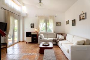 a living room with a white couch and a table at THEA MARE villa in Nea Potidaea