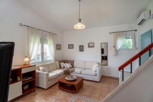 a living room with a couch and a table at THEA MARE villa in Nea Potidaea