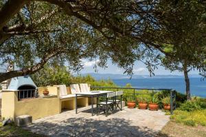 a table and chairs on a patio with a view of the ocean at THEA MARE villa in Nea Potidaea