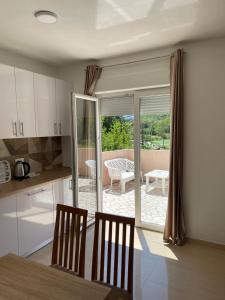 a kitchen with a table and chairs and a patio at Apartment with pool Tomic Boka Bay in Herceg-Novi