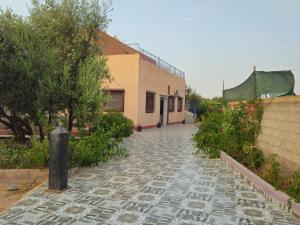 a cobblestone walkway next to a building with a building at Villa route ourzazate in Aït Ourir