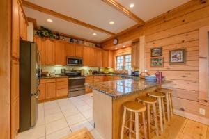 a kitchen with wooden cabinets and a large island with bar stools at Fox Crossing in Banner Elk