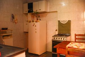 a kitchen with a white refrigerator and a stove at Pousada 3 Bruxas Casa de Hóspedes in São Thomé das Letras +26 photos