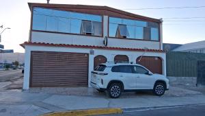 a white suv parked in front of a building at Hostal Mejillones in Mejillones
