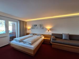 a hotel room with a bed and a couch at Soldanella in Lech am Arlberg