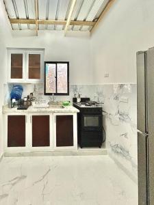 a kitchen with white marble floors and a stove at Mi Refugio 3 in Río San Juan