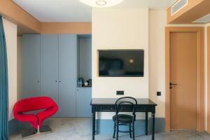 a room with a table and two chairs and a television at Proza Hotel & Restaurant in Kutaisi