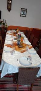 a long table with plates and glasses on it at Sófalvi Vendégház in Sîntimbru