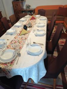 a long table with plates and napkins on it at Sófalvi Vendégház in Sîntimbru +9 photos