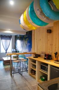 a room with a kitchen with a table and stools at La Playa - 5 couchages climatisé in Romans-sur-Isère