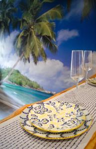 a table with a plate and two wine glasses at La Playa - 5 couchages climatisé in Romans-sur-Isère