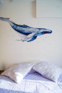 a whale head on a wall above a bed at La Playa - 5 couchages climatisé in Romans-sur-Isère +6 photos