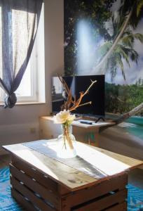 a table with a vase of flowers on top of a desk at La Playa - 5 couchages climatisé in Romans-sur-Isère