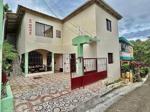 a house with a red gate in front of it at Mi Refugio 3 in Río San Juan