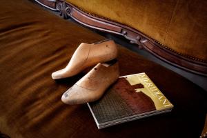 a pair of boots and a book on a bed at Il Ciabattino di Ceva in Ceva