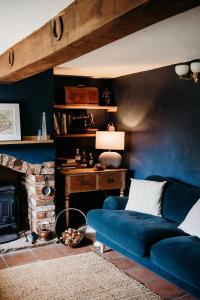 a living room with a blue couch and a fireplace at Staneve Cottage in Docking