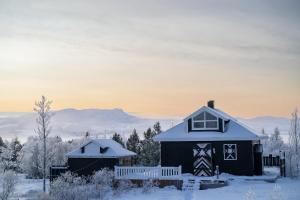 a black house with snow on it in the snow at Solhaven in Selfoss