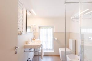 ein weißes Badezimmer mit Waschbecken und Toilette in der Unterkunft Hotel Eden in Sistiana
