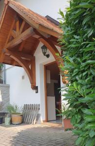 a wooden arched entry to a house with a bench at Ferienwohnung am Rebhang in Sasbachwalden