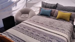 a bedroom with a large bed with pillows and a bed sqor at Summer IGLOO by the sea in COCOland in Pálioura