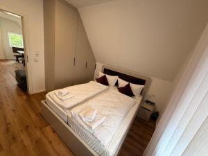 a bedroom with a bed with white sheets and pillows at HeideSuite Soltau in Soltau