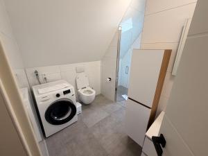 a small bathroom with a washing machine and a toilet at HeideSuite Soltau in Soltau