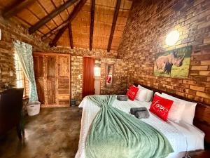 a bedroom with a bed in a brick wall at Zaganaga Kruger Lodge in Marloth Park +45 photos
