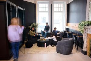 a group of people sitting in a living room at Capsule Residence in Montreal