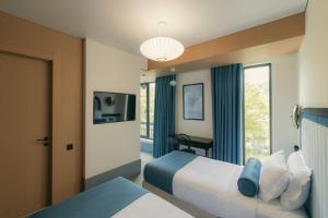 a hotel room with two beds and a window at Proza Hotel & Restaurant in Kutaisi