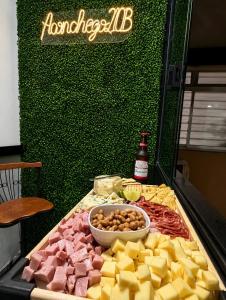 a table topped with cheese and meats and a bottle of beer at Ap Aconchego 210 B in Ubatuba