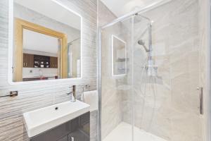 a bathroom with a shower and a sink and a mirror at The Terrace Collection Number 2 in Tramore +17 photos