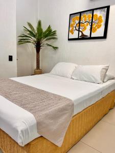 a bedroom with a large bed and a palm tree at Adarax Playa Hermosa in Cancún